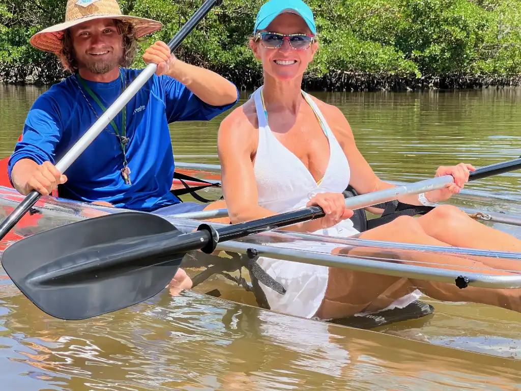 Guests in a clear tandem kayak viewing fish below the surface