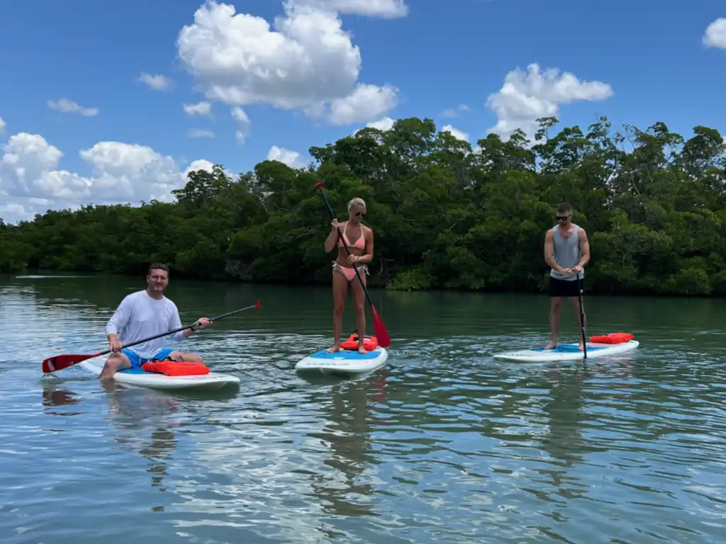 Group of friends paddleboarding on calm waters near Big Hickory Island, Bonita Springs
